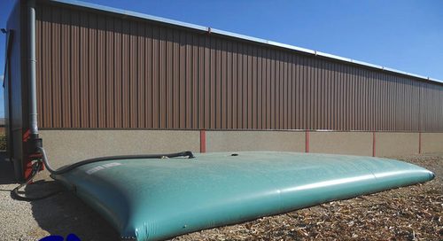 rain water bladders tanks Rain water collecting flexible bladder tank install next to a warehouse building with piping connections