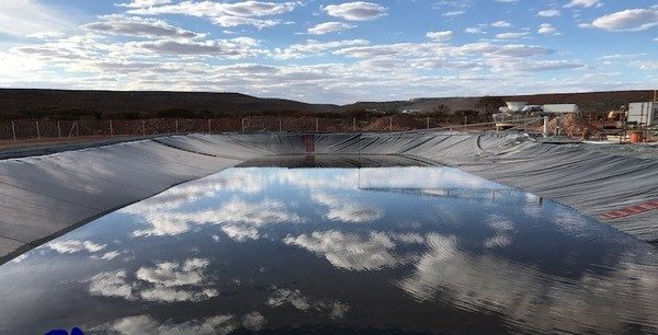 Water filled tailing dam fitted with black liner at a mine site