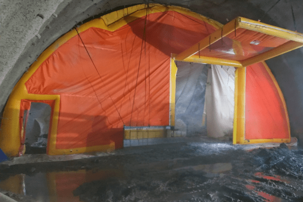 Inflatable brattice wall installed inside a large underground tunnel